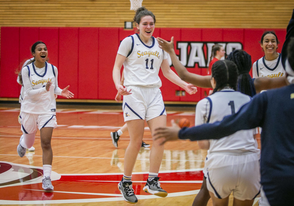 Everett’s Lanie Thompson jumps in the air and runs to her teammates after beating Snohomish to advance to state on Saturday, Feb. 18, 2023 in Everett, Washington. (Olivia Vanni / The Herald)

