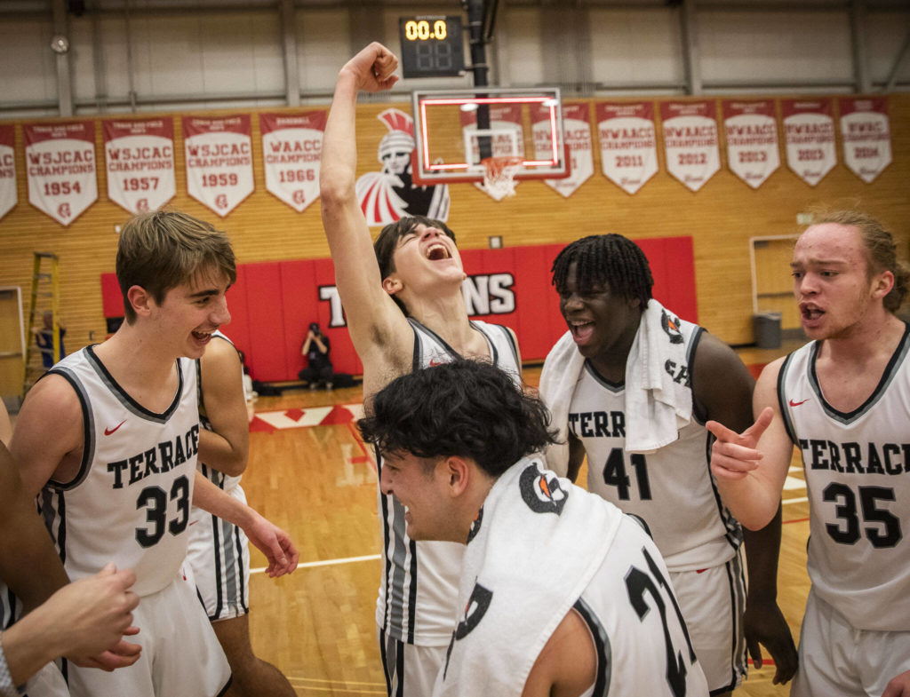 Mountlake Terrace players celebrate beating Arlington to become the 3A District 1 champions Feb. 18 in Everett. The sixth-seeded Hawks face third-seeded Eastside Catholic on Saturday. (Olivia Vanni / The Herald)
