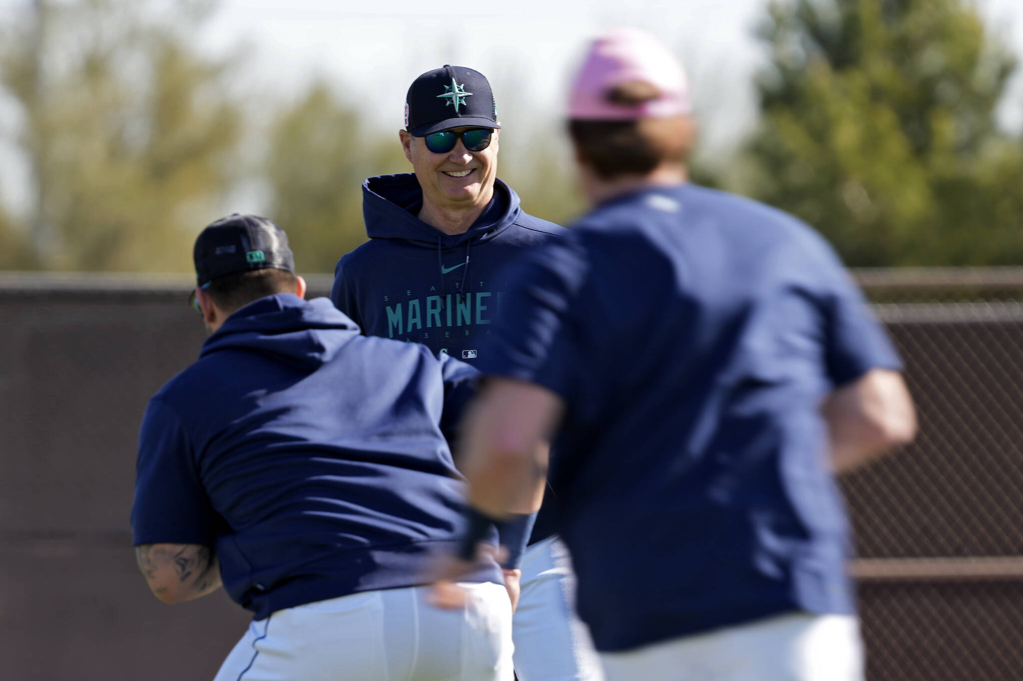 Mariners manager Scott Servais watches players warm up before a spring training practice this past Saturday in Peoria, Ariz. (AP Photo/Charlie Riedel)