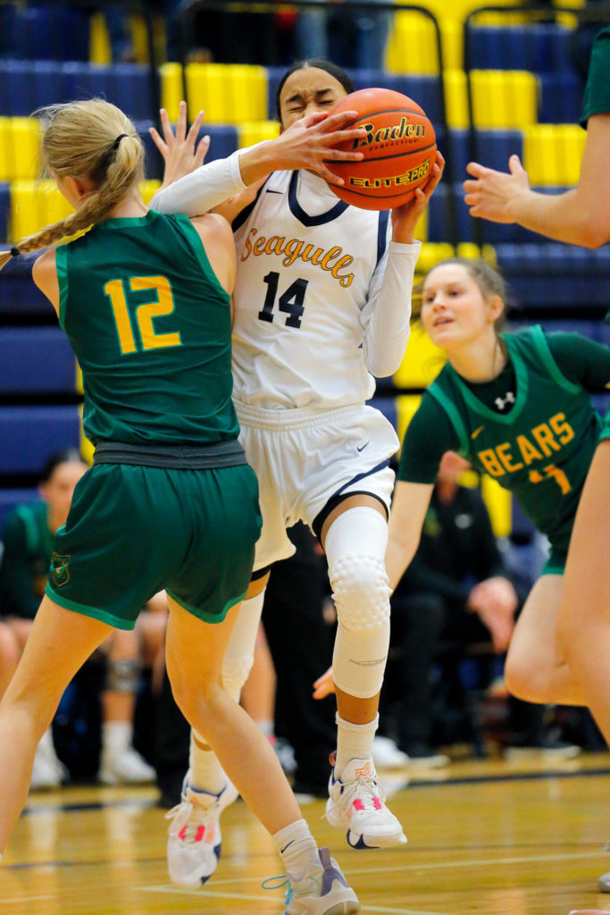 Everett’s Mae Washington gets hit hard while driving to the net against Bishop Blanchet during a first round playoff game on Tuesday, Feb. 21, 2023, at the Norm Lowery Gymnasium in Everett, Washington. (Ryan Berry / The Herald)
