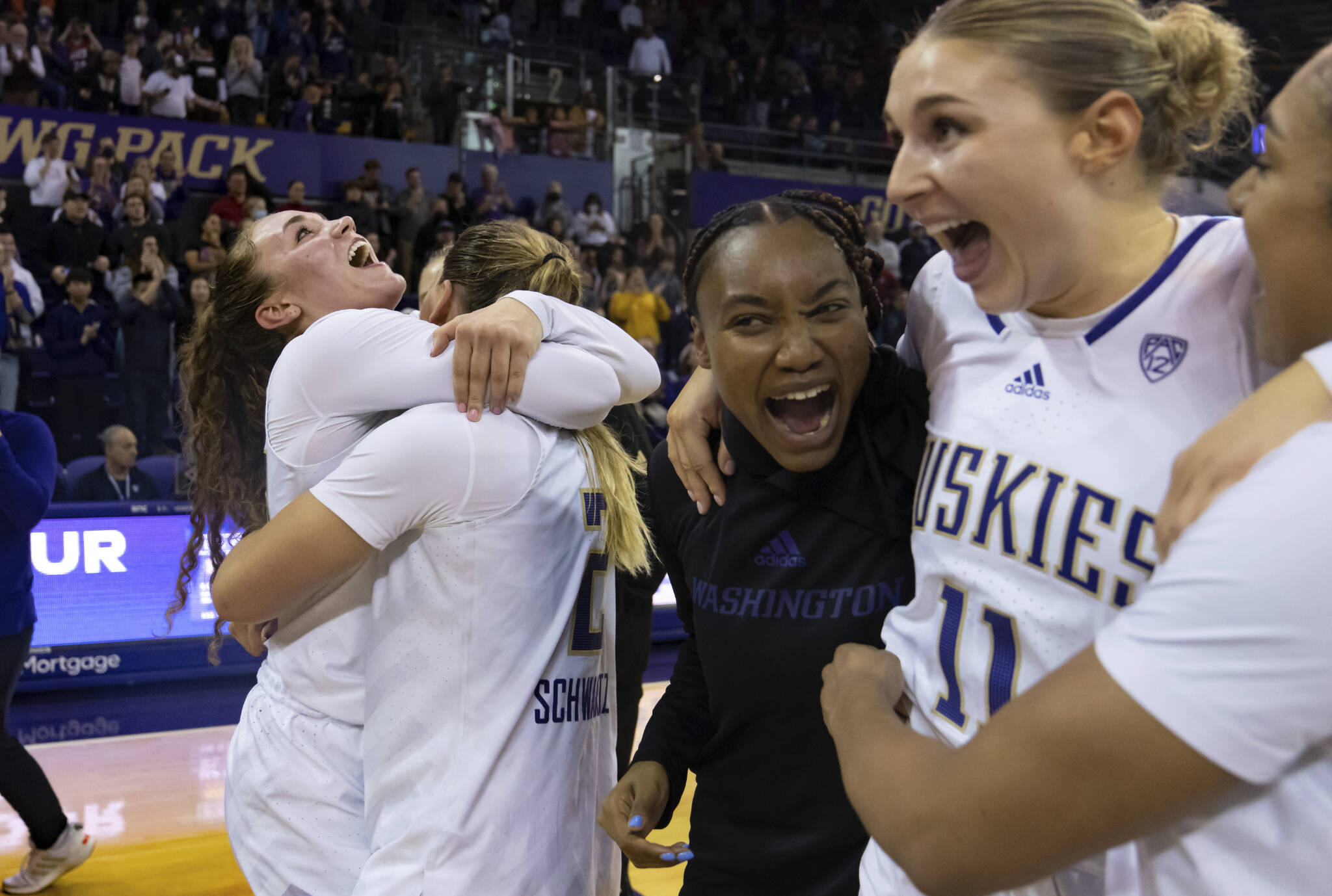 Washington players including guard guard Elle Ladine (far left), forward Lauren Schwartz (second from left), and forward Haley Van Dyke (second from right) celebrate after beating Stanford 72-67 on Feb. 5 in Seattle. (AP Photo/Stephen Brashear)