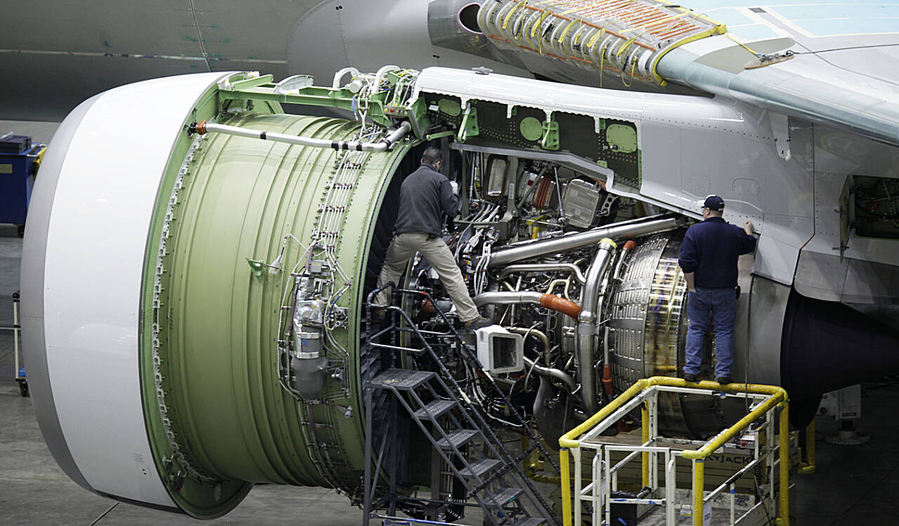 Employees work near an engine of a Boeing 777 at Boeing Co.’s airplane assembly plant in Everett in January, 2009. (Ted S. Warren / Associated Press file photo)