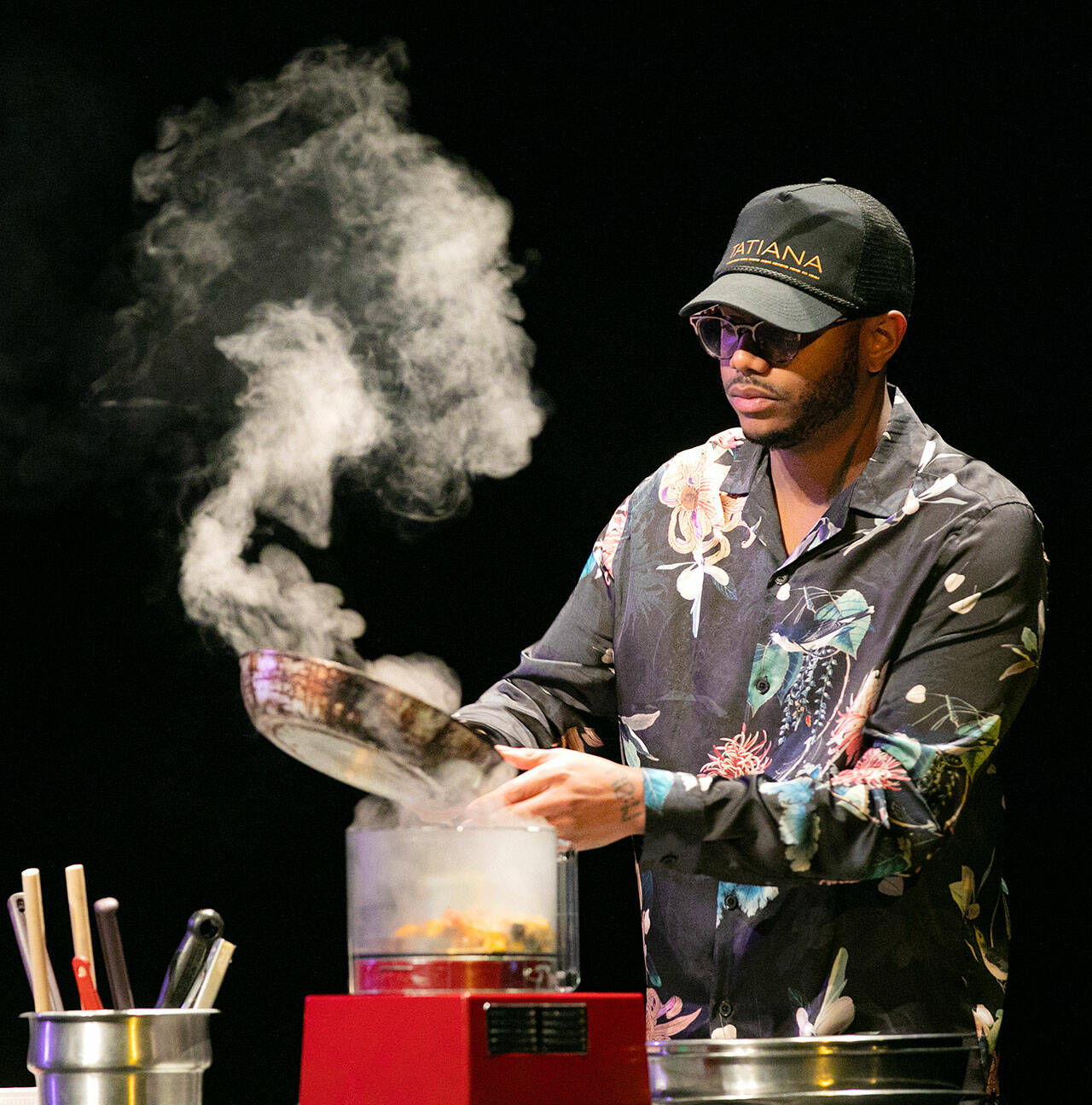 Chef Kwame Onwuachi cooks an eggplant dish during a keynote presentation as part of the Everett Public Library’s “One Everett One Book” program Friday at the Everett Performing Arts Center. (Ryan Berry / The Herald)