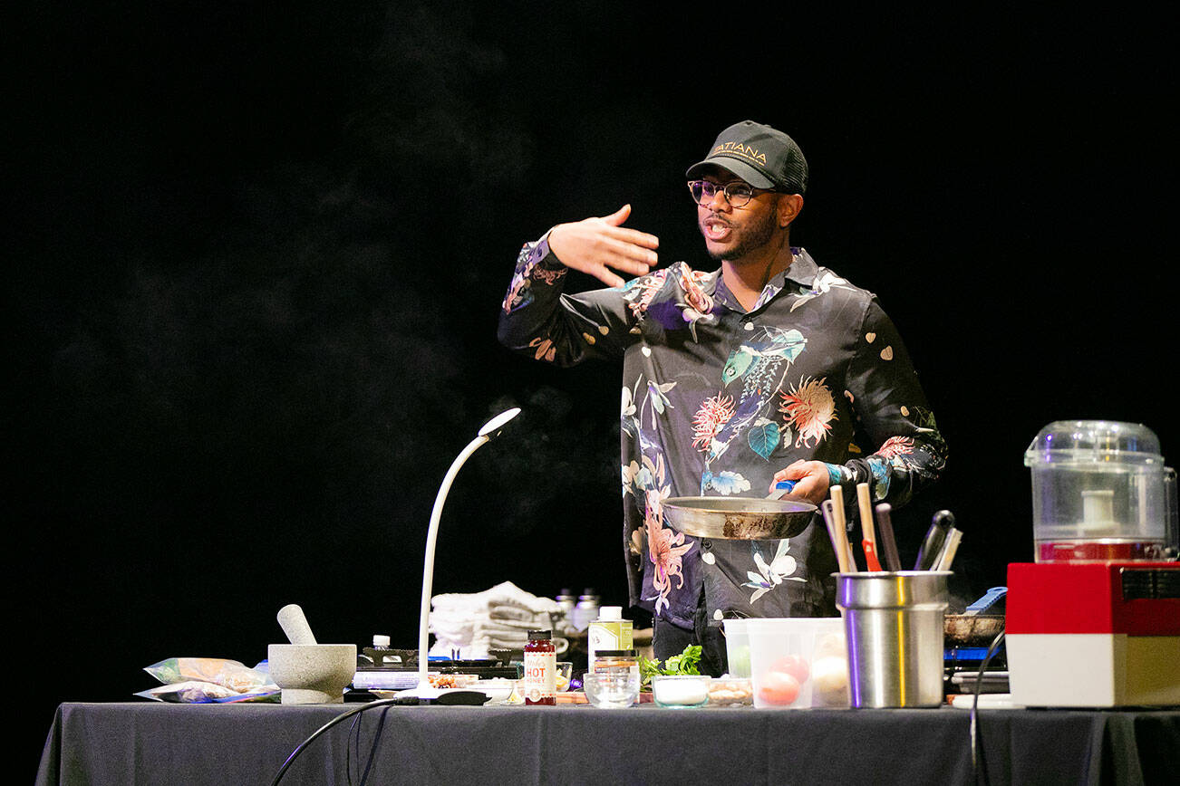 Chef Kwame Onwuachi cooks an eggplant dish during a keynote presentation at the Everett Performing Arts Center as part of Everett Public Library’s “One Everett One Book” program on Friday, Feb. 24, 2023, in downtown Everett, Washington. (Ryan Berry / The Herald)