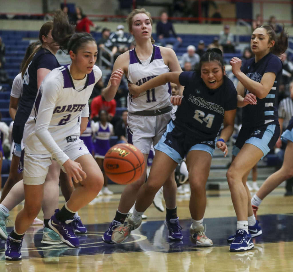 Players scramble for the ball during a 3A girls basketball state regional game between Garfield and Meadowdale at the Courter Family Athletic Pavilion in Bellevue on Friday. Garfield won 62-48. (Annie Barker / The Herald)
