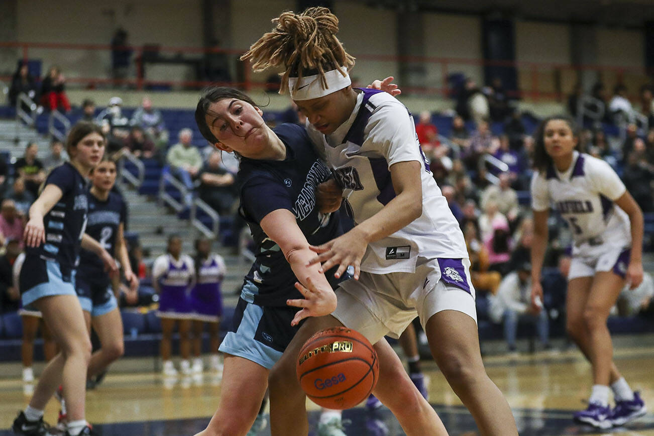 Meadowdale’s Natalie Durbin (10) and Garfield’s Rakiyah Jackson (20) fight for the ball during the 3A Girls basketball round two game between Meadowdale and Garfield at the Courter Family Athletic Pavilion in Bellevue, Washington on Friday, Feb. 24, 2023. Garfield won, 62-48. (Annie Barker / The Herald)