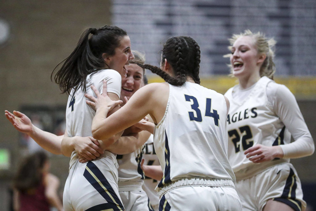 Arlington players celebrate during a state playoff game against Lakeside at Arlington High School on Saturday. Arlington won 75-63. (Annie Barker / The Herald)
