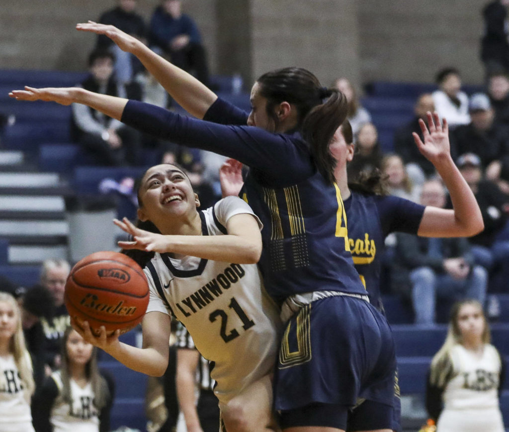 Lynnwood’s McKenzie Ruse-Martin (21) shoots the ball during a state playoff game against West Seattle at Arlington High School on Saturday. Lynnwood won 47-45. (Annie Barker / The Herald)
