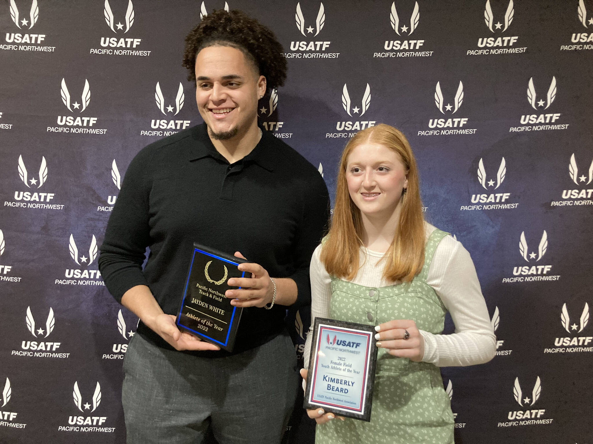 Everett graduate Jayden White (left) and Mukilteo resident Kimberly Beard hold up their awards from USATF Pacific Northwest Association’s 2022 banquet on Feb. 18 in Tukwila. (Provided photo)