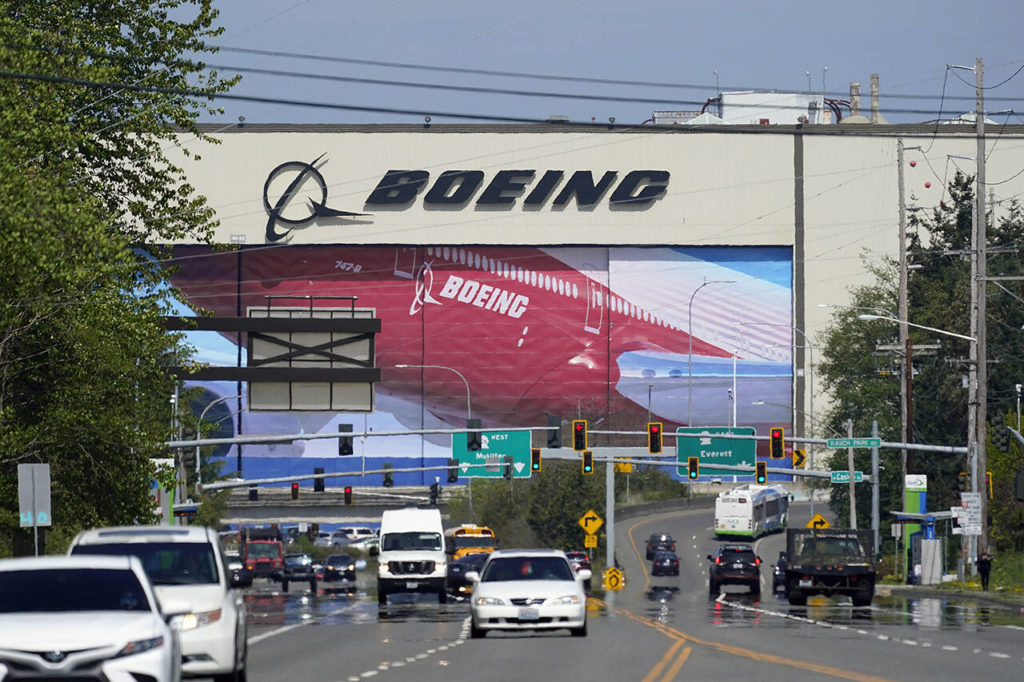 Traffic drives in view of a massive Boeing Co. production plant, where images of jets decorate the hangar doors, on April 23, 2021, in Everett. (AP Photo / Elaine Thompson)
