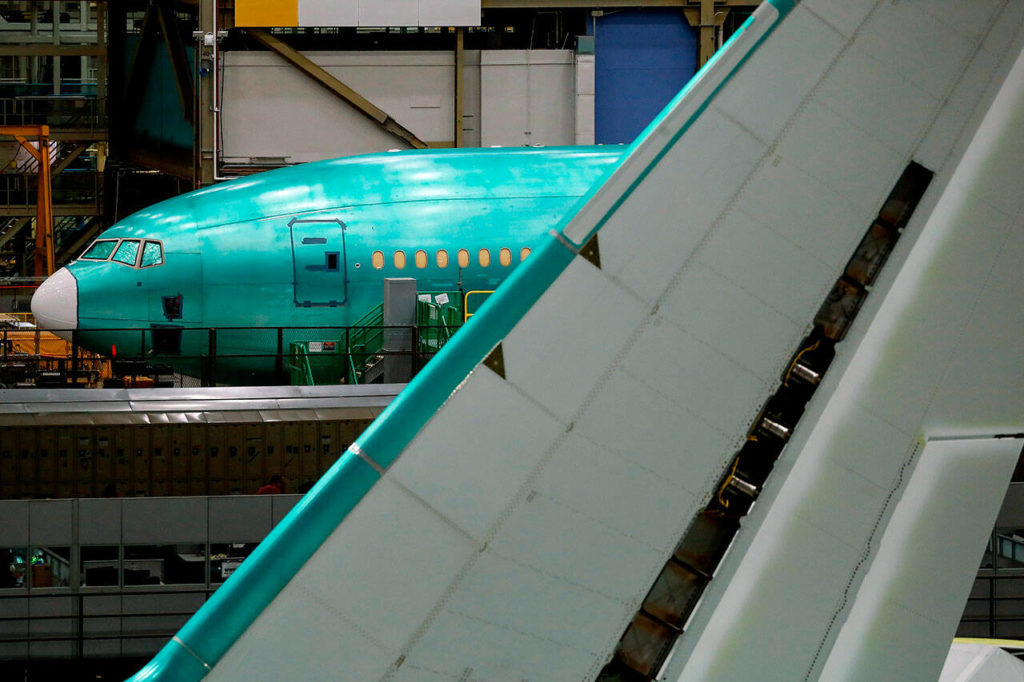 A 777X is seen behind the tail of a 777 freighter at Boeing’s Everett Production Facility on June 15, in Everett. (Jennifer Buchanan/The Seattle Times via AP, Pool)

