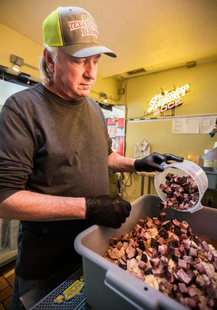 Jeff Knoch, owner of Jeff’s Texas Style BBQ, pours brisket into his signature brisket baked beans on Jan. 13, 2022 in Marysville. (Olivia Vanni / The Herald)
