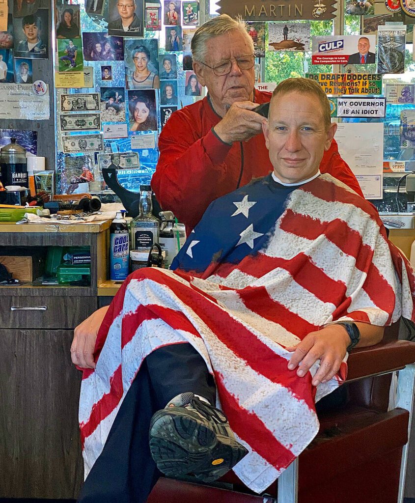Barber Bob Martin (left) cuts the hair of a customer who declined to identify himself on July 30, 2020. (Andrea Brown / The Herald)
