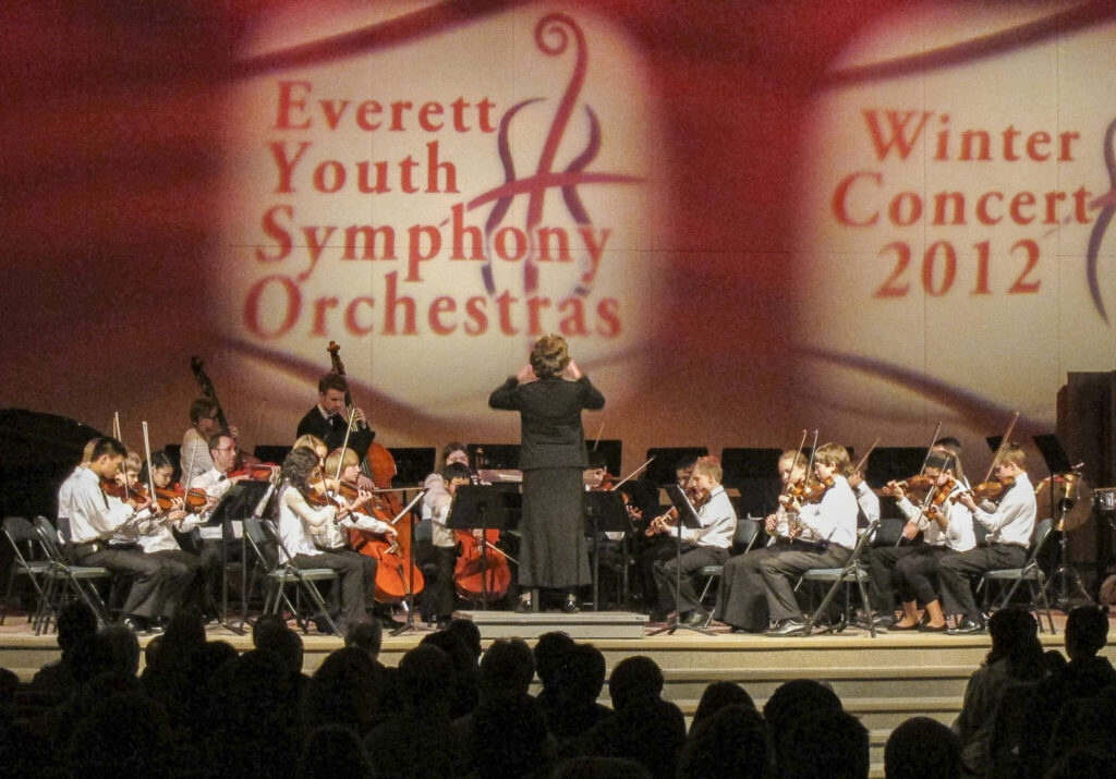Cheryl Harris (center) conducting Everett Youth Symphonys Young Strings. Before she began conducting in the late 1990s, Harris was a librarian for the organization for almost a decade. (Family photo)
