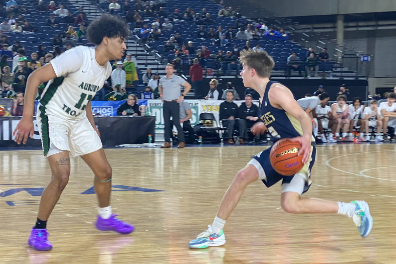 Arlington's Leyton Martin (right) brings the ball up court against Auburn's Tyrell Nichols during a 3A state playoff game on Wednesday, March 1, 2023, at the Tacoma Dome. (Nick Patterson / The Herald)