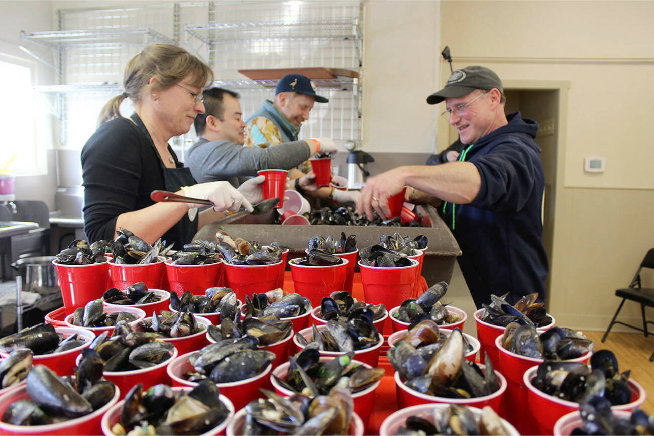During the 2018 Musselfest in Coupeville, Laura and Rawle Jefferds of Penn Cove Shellfish help fill cups for the mussel-eating contest.  This year’s festival is March 4-5. File photo by Patricia Guthrie/Whidbey News-Times