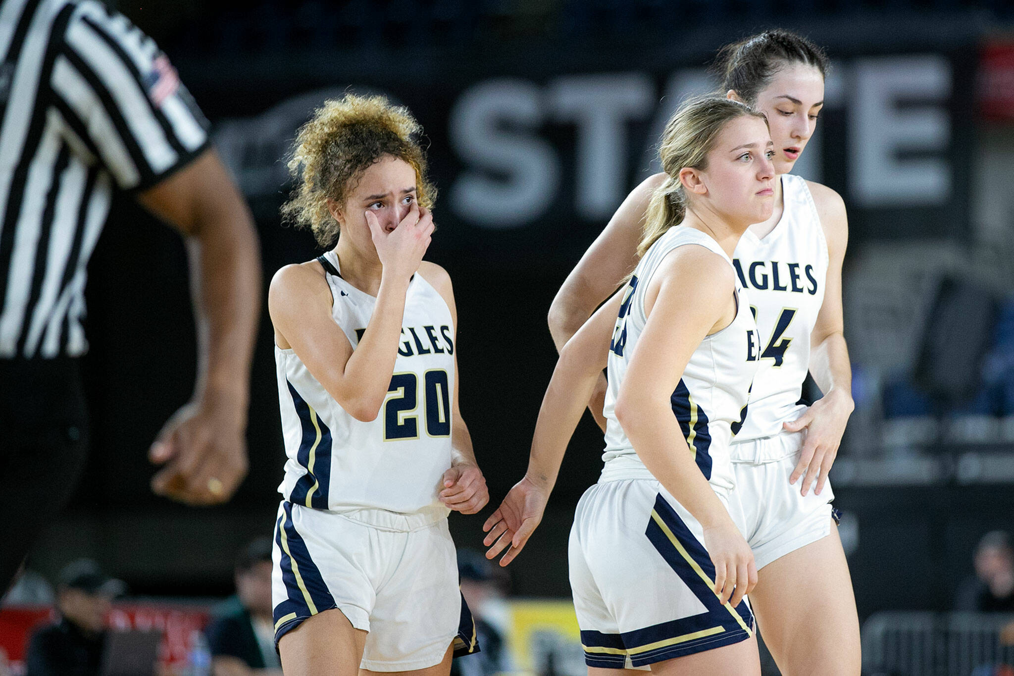 Arlington’s Samara Morrow, Jersey Walker and Jenna Villa walk off the court after losing to Lake Washington in the 3A semifinal on Friday, March 3, 2023, at the Tacoma Dome in Tacoma, Washington. (Ryan Berry / The Herald)