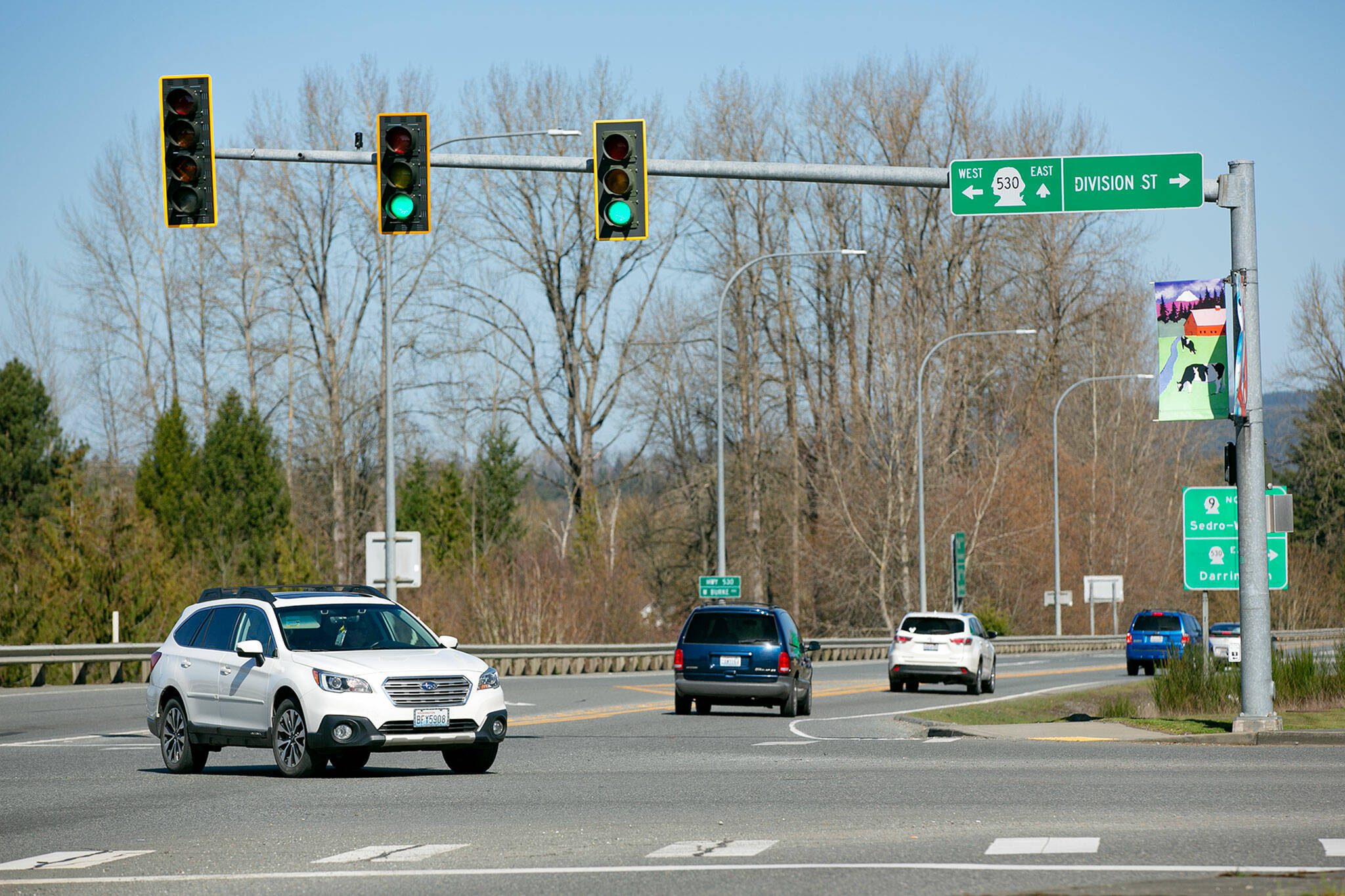 A driver makes a permitted left turn on a flashing yellow arrow at the intersection of Highway 9 and Highway 530 on Wednesday in Arlington. (Ryan Berry / The Herald)