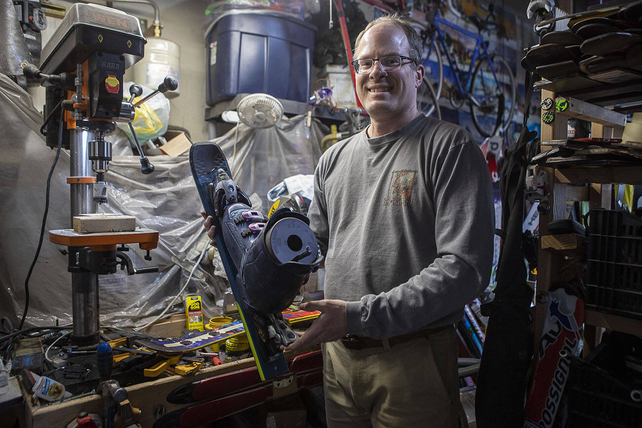 Brian Geppert holds a birdhouse made of skis at his home in Lynnwood, Washington on Saturday, March 11, 2023. Geppert started a recycling program for the greater Seattle area, which has saved hundreds of skis from their demise. He turns the skis into functional art for the home, such as coat racks, bottle openers, bookends, shelves, candle sconces, toilet plungers, beer flights, and more. (Annie Barker / The Herald)