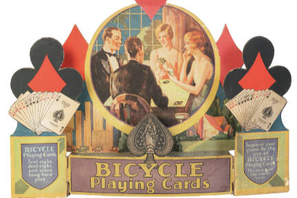 When advertisements include pictures of people, their clothing and hairstyles can help date the item. This store display for Bicycle Playing Cards is from about 1930.