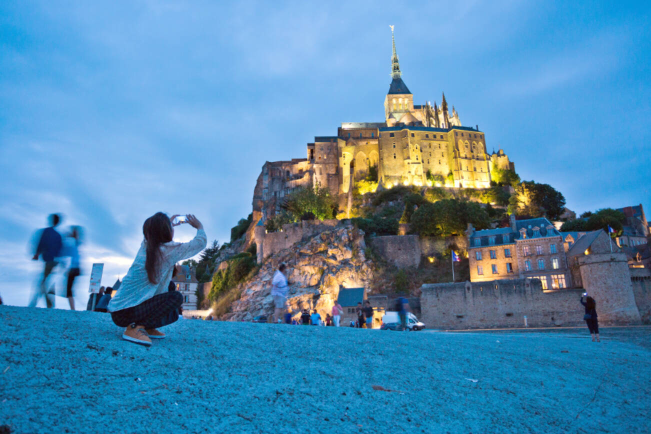 Christian pilgrims and tourists are drawn to the dramatically situated Mont St-Michel, a soaring island abbey in Normandy that is completely surrounded by the sea at high tide.