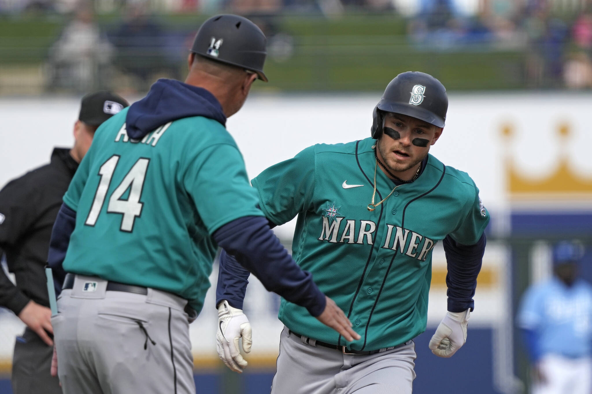 The Mariners’ Jarred Kelenic (right) celebrates with third base coach Manny Acta after hitting a two-run home run during the third inning of a spring game against the Royals on Feb. 26 in Surprise, Ariz. (AP Photo/Charlie Riedel)