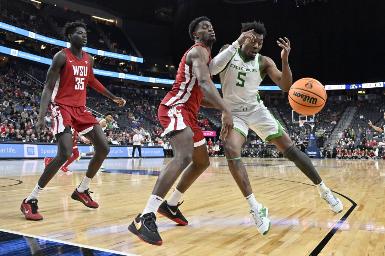 Washington State guard TJ Bamba and Oregon guard Jermaine Couisnard (5) chase the ball during the second half of a Pac-12 Tournament quarterfinal game Thursday in Las Vegas. (AP Photo/David Becker)