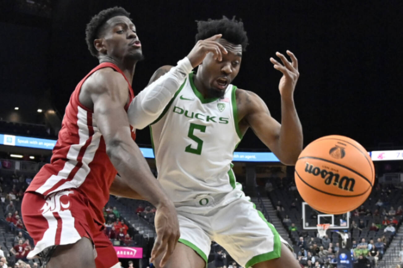 Washington State guard TJ Bamba, center and Oregon guard Jermaine Couisnard (5) chase the ball during the second half of an NCAA college basketball game in the quarterfinals of the Pac-12 Tournament, Thursday, March 9, 2023, in Las Vegas. (AP Photo/David Becker)