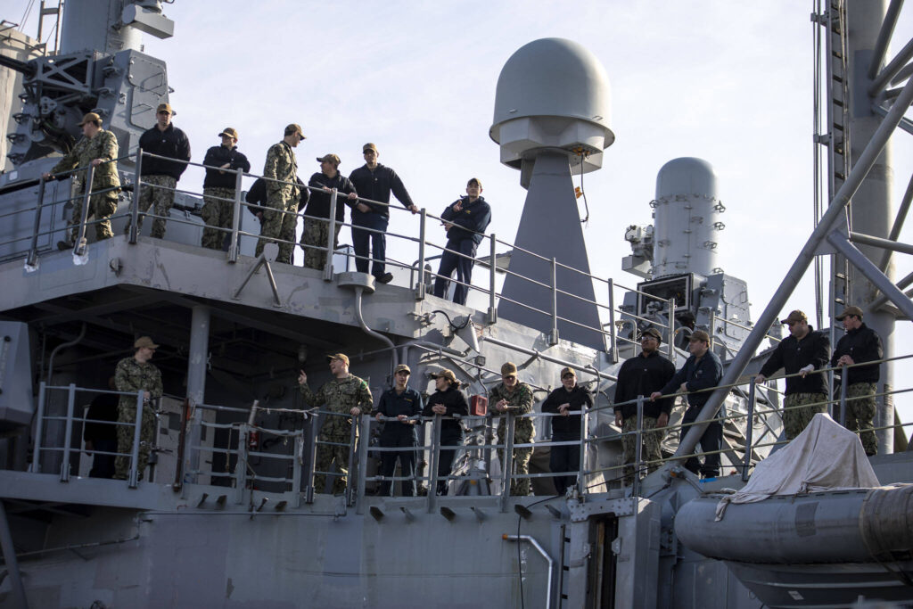 People watch from an adjacent ship for the USS Barry to come into port in Everett, Washington on Friday, March 17, 2023. The USS Barry arrived to its new homeport at Everett Naval Station, previously from Yokosuka, Japan. The crew is led by Commanding Officer, Cmdr. Grant Bryan. (Annie Barker / The Herald)

