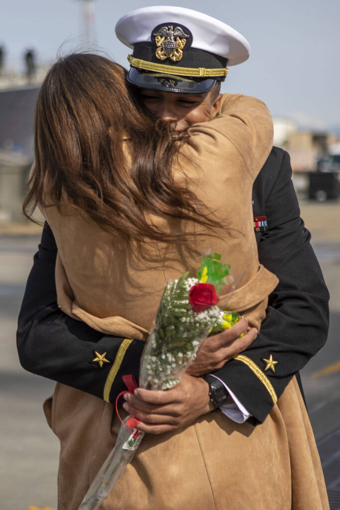 Brandon Troutman and Heather Stump hug in Everett, Washington on Friday, March 17, 2023. The USS Barry arrived to its new homeport at Everett Naval Station, previously from Yokosuka, Japan. The crew is led by Commanding Officer, Cmdr. Grant Bryan. (Annie Barker / The Herald)
