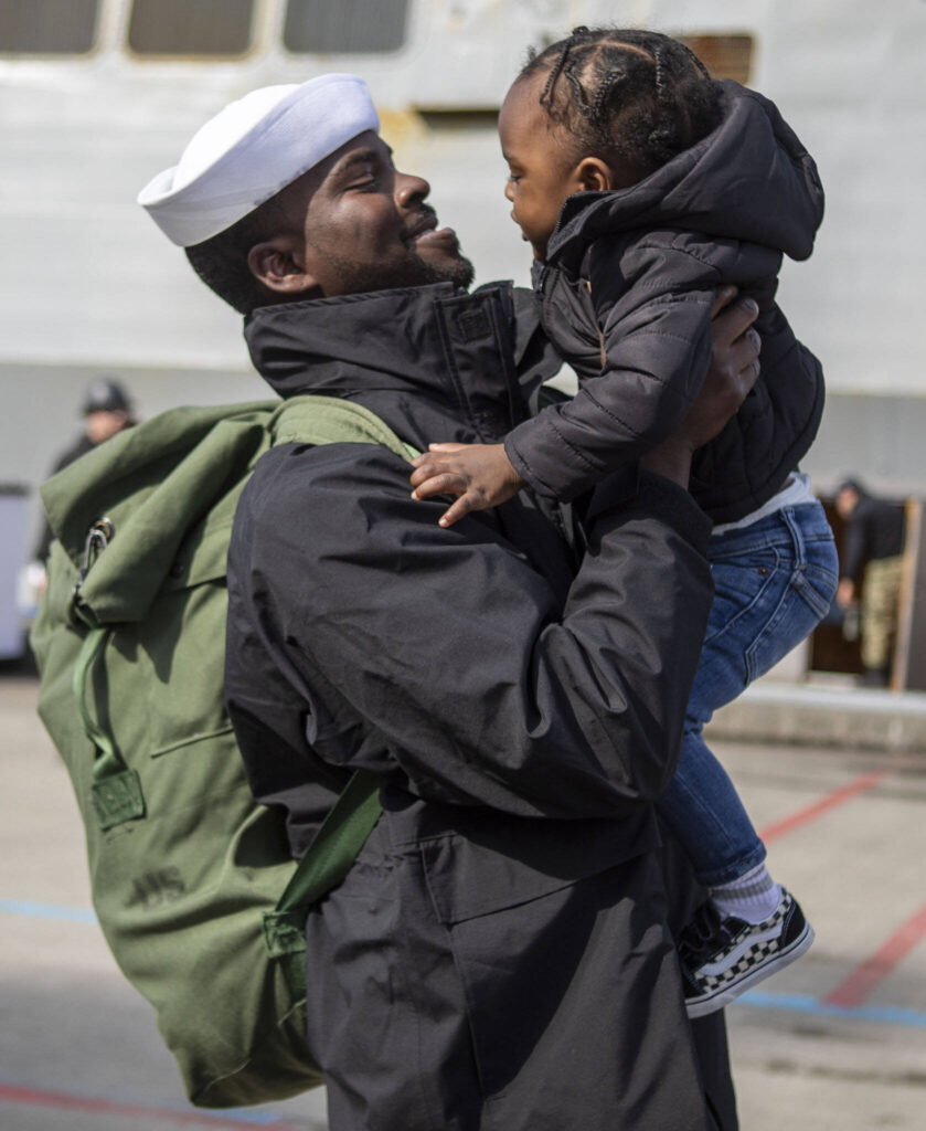Jeremy Stover holds his son Jeremiah Stover, 2, in Everett, Washington on Friday, March 17, 2023. The USS Barry arrived to its new homeport at Everett Naval Station, previously from Yokosuka, Japan. The crew is led by Commanding Officer, Cmdr. Grant Bryan. (Annie Barker / The Herald)
