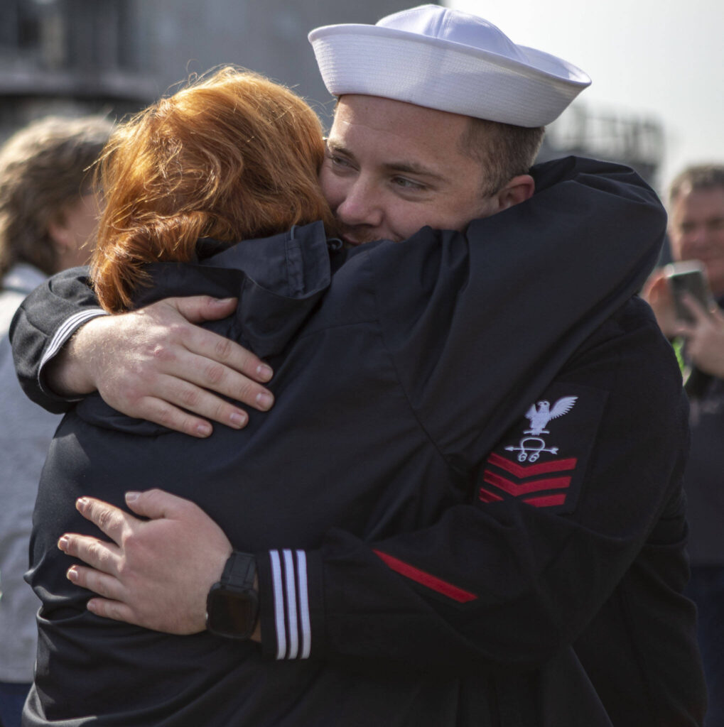 Ben Anderson, right, hugs his grandmother Rosemary Grew, left, in Everett, Washington on Friday, March 17, 2023. The USS Barry arrived to its new homeport at Everett Naval Station, previously from Yokosuka, Japan. The crew is led by Commanding Officer, Cmdr. Grant Bryan. (Annie Barker / The Herald)
