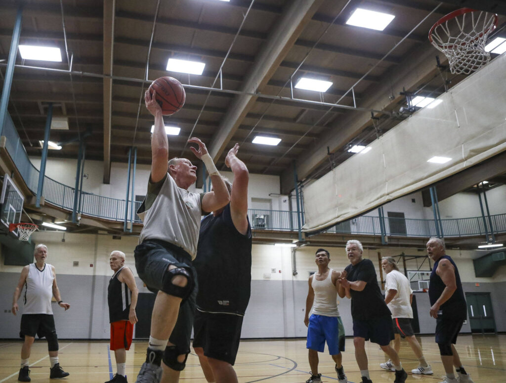 John White, 66, shoots the ball during a pick-up basketball game at the Marysville YMCA in Marysville, Washington, on Monday, March 13, 2023. (Annie Barker / The Herald)
