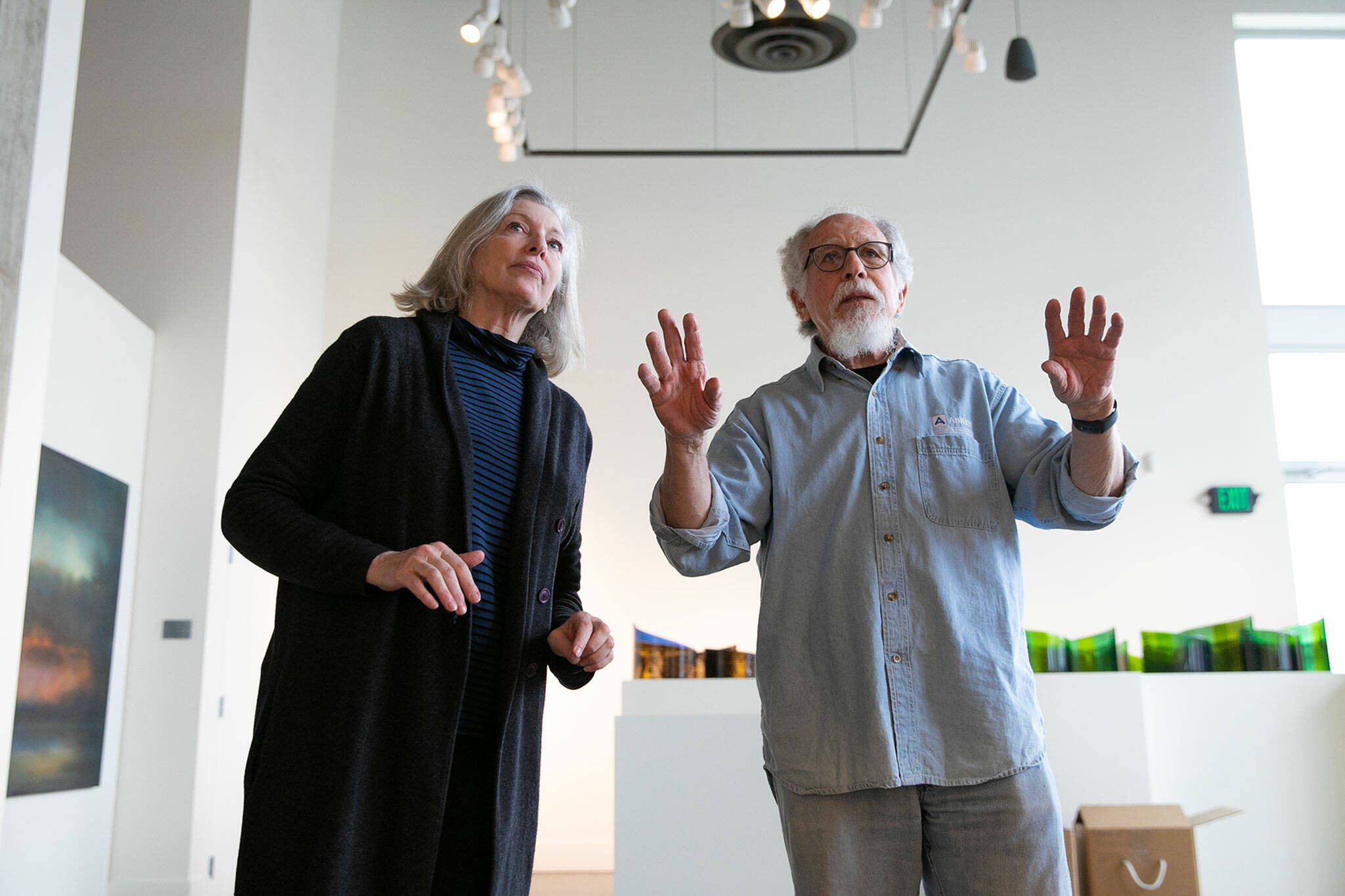Guest curators Meg Holgate and Steve Klein discuss the positioning of a piece on the gallery wall during the installation of A Precarious Edge at Schack Art Center on Sunday, March 19, 2023, in Everett, Washington. The two Washington artists are featuring their environment-oriented work on the main floor and curating an exhibit called Exploring The Edge on the mezzanine gallery that features nine other area artists. (Ryan Berry / The Herald)