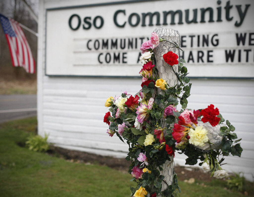A cross is decorated with flowers in dedication of mudslide victims at the Oso Community Chapel Wednesday, Mar. 26, 2014, in Oso, Washington. 
