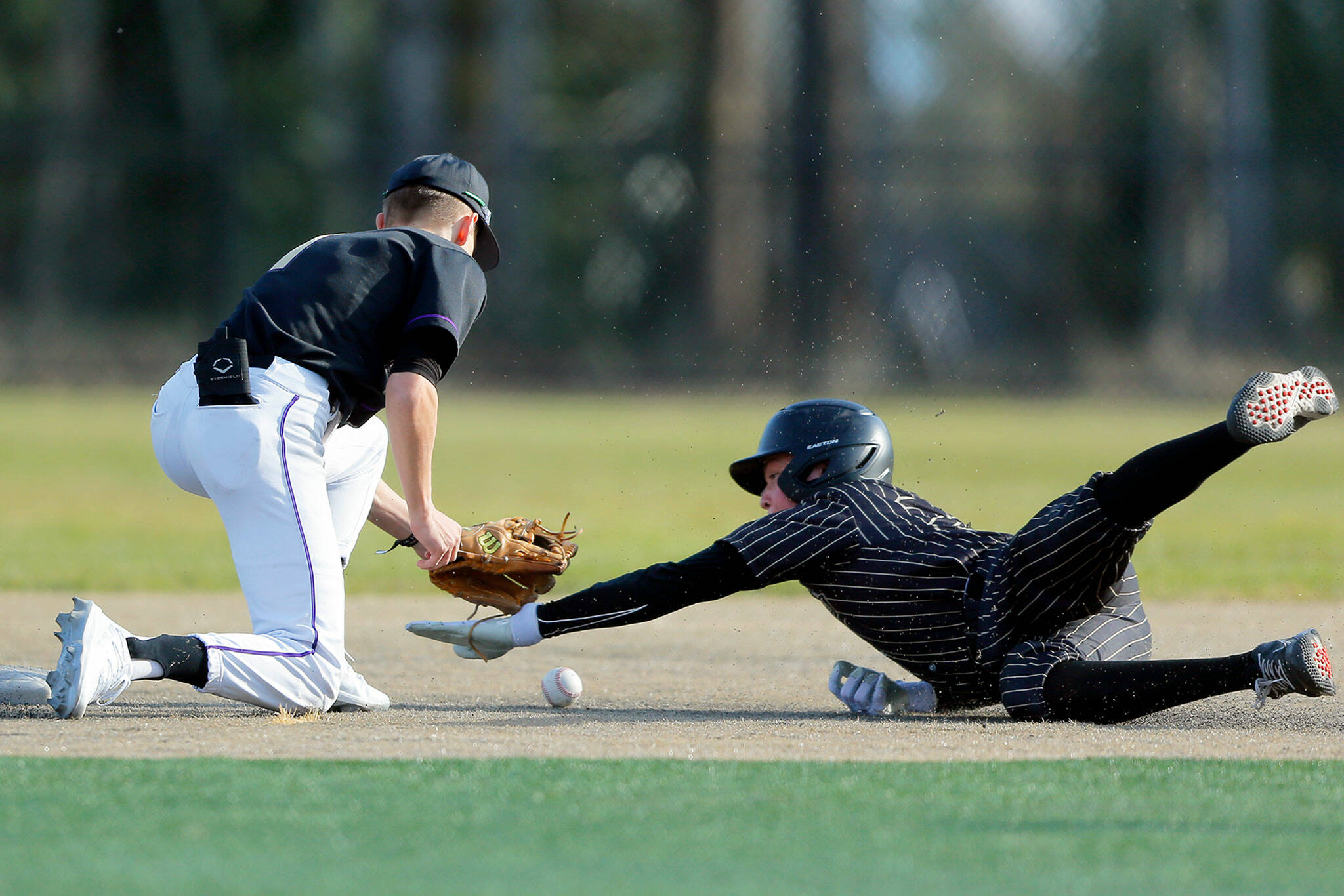 Lynnwood’s Douglas McGuire slides in safe on a steal attempt during a game against Lake Stevens on Friday, March 17, 2023, at Lake Stevens High School in Lake Stevens, Washington. (Ryan Berry / The Herald)