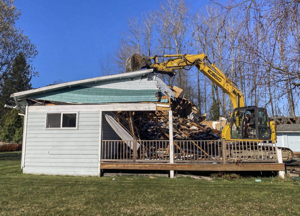 A residential home is demolished at what will be the site of a new Lake Stevens Library on Wednesday, March 22, 2023 in Lake Stevens, Washington. (Sophia Gates / The Herald).
