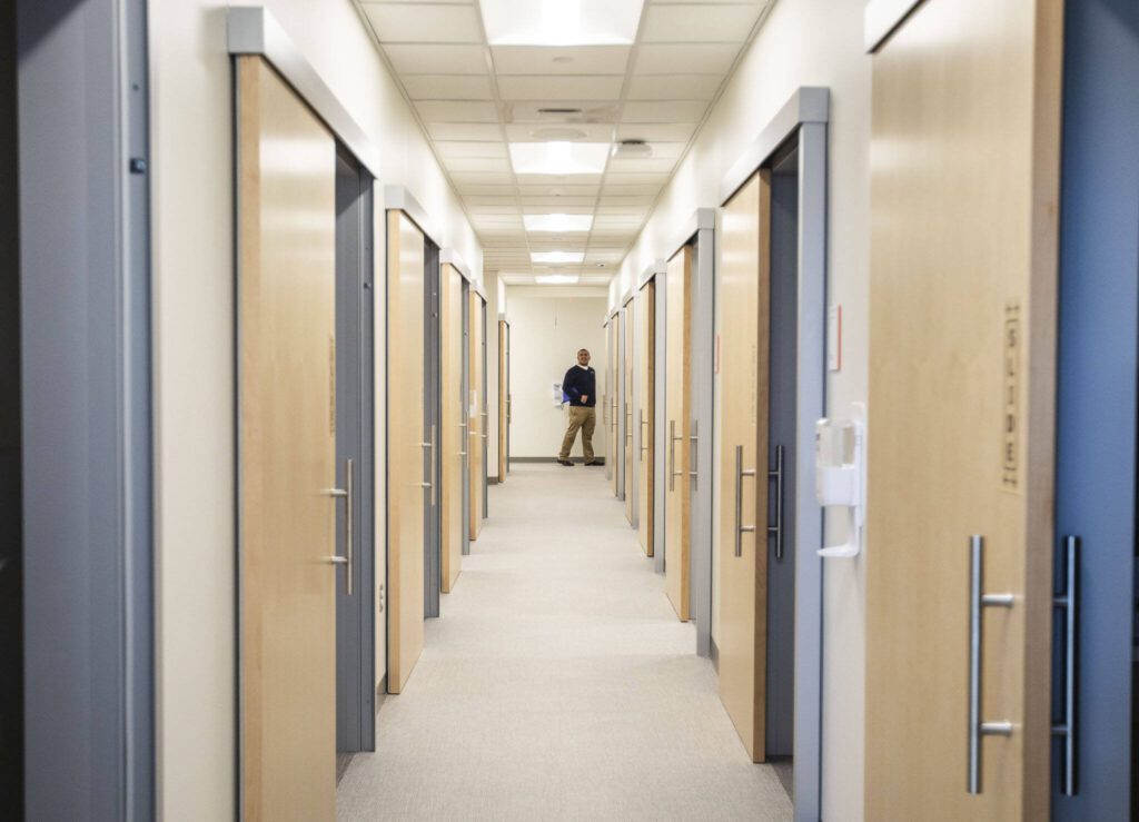 A person stares down a long hallway of examination rooms in the new Arlington Everett Clinic on Monday, March 27, 2023 in Arlington, Washington. (Olivia Vanni / The Herald)
