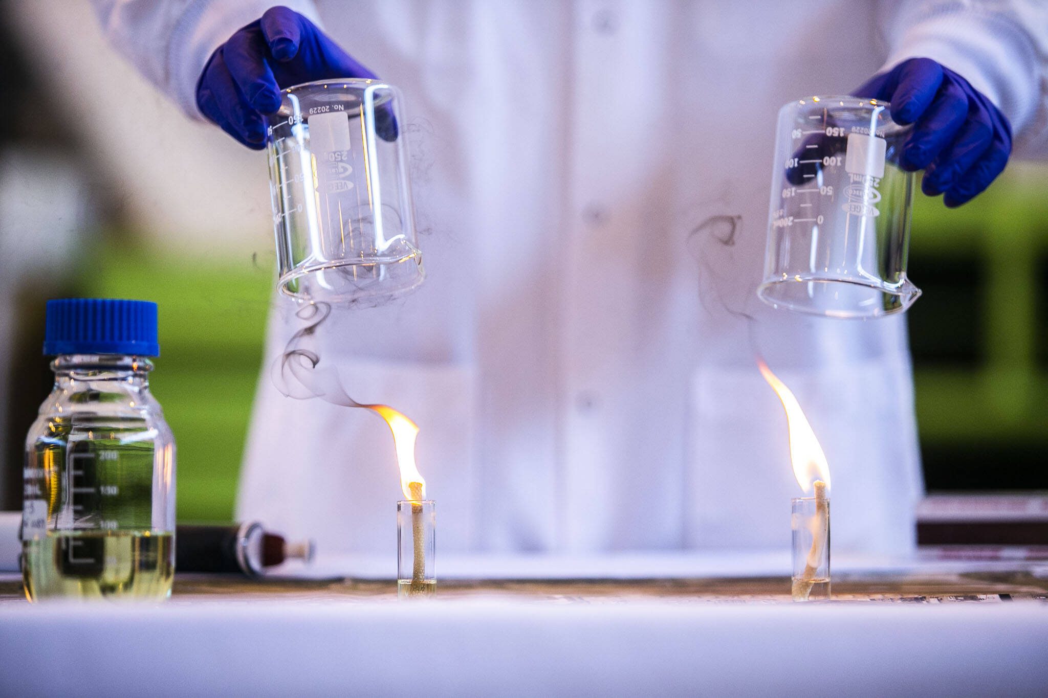 A standard jet fuel, left, burns with extensive smoke output while a 50 percent SAF drop-in jet fuel, right, puts off less smoke during a demonstration of the difference in fuel emissions on Tuesday, March 28, 2023 in Everett, Washington. (Olivia Vanni / The Herald)