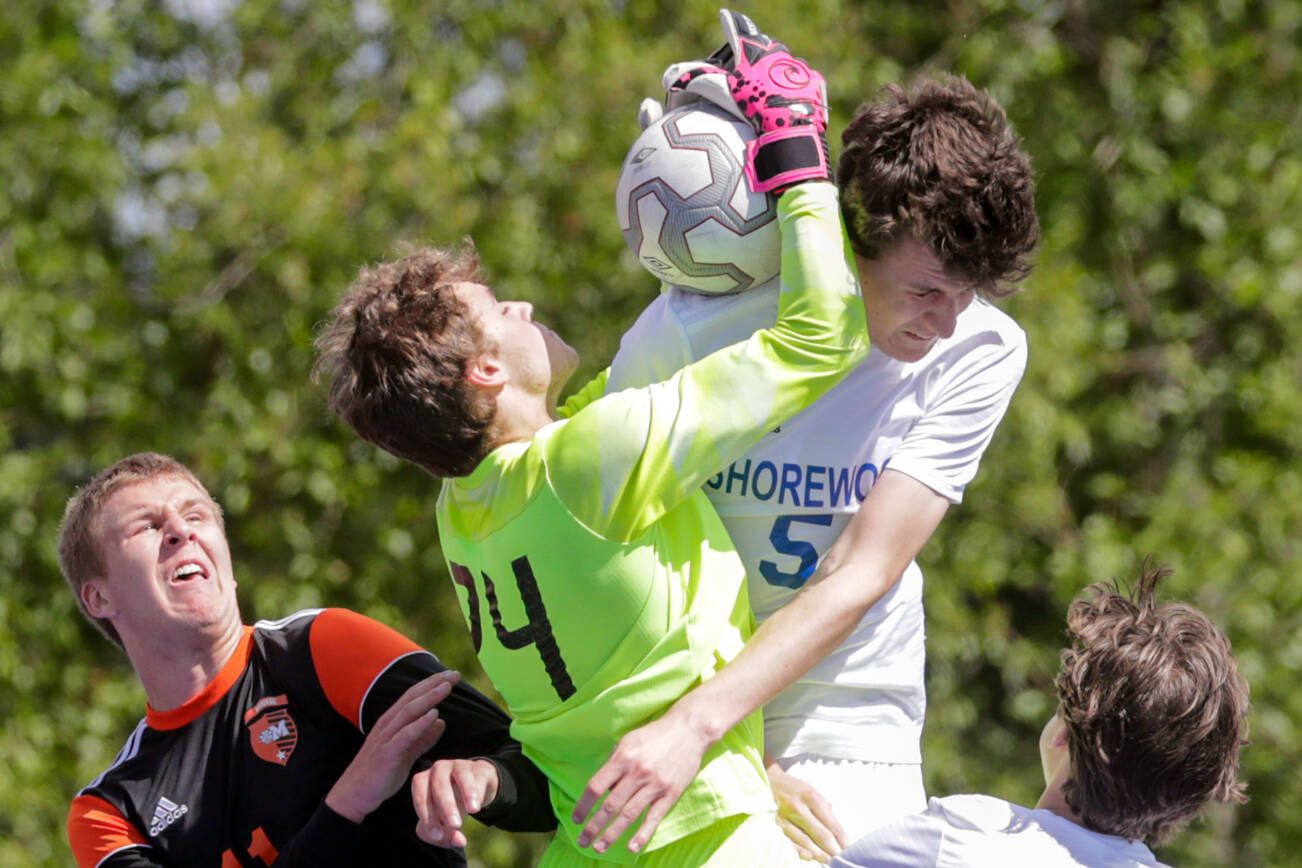 Monroe’s goalkeeper Dustin Jenkins grabs a shot attempt with Shorewood's Ethan Farley crashing in Saturday afternoon at Shoreline Stadium in Shoreline, Washington on May 14, 2022.  The Bearcats won 2-0. (Kevin Clark / The Herald)