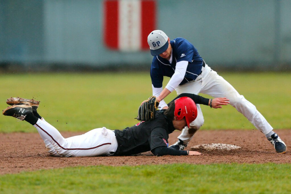 A Snohomish runner is almost tagged out at second against Glacier Peak on Friday, March 31, 2023, at Earl Torgeson Field in Snohomish, Washington. (Ryan Berry / The Herald)
