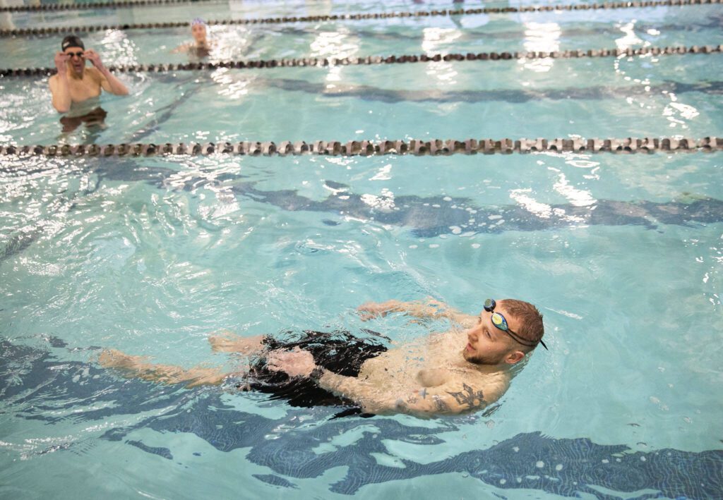 James Hessen chats with his coach Lucie LaMaine during a practice at the Everett YMCA on Friday, March 17, 2023 in Everett, Washington. (Olivia Vanni / The Herald).
