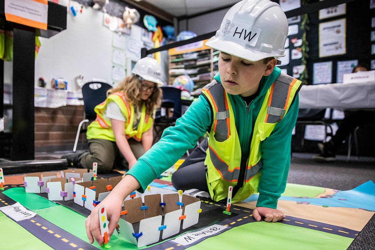 Matthew Sims places a traffic signal for his group's traffic project presentation at Hazelwood Elementary School on Wednesday, March 29, 2023, in Lynnwood, Washington. (Olivia Vanni / The Herald)