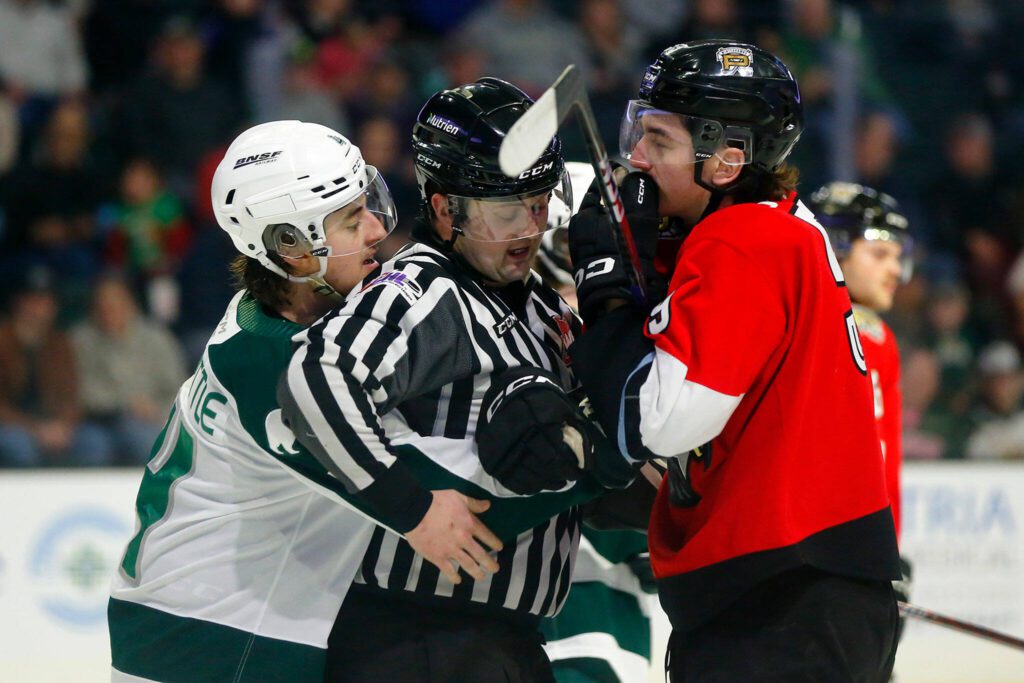 A ref gets between Everett’s Dexter Whittle and Portland’s Carter Sotheran as they bicker during Game 3 of a first-round WHL playoff series on Monday at Angel of the Winds Arena in Everett. (Ryan Berry / The Herald)
