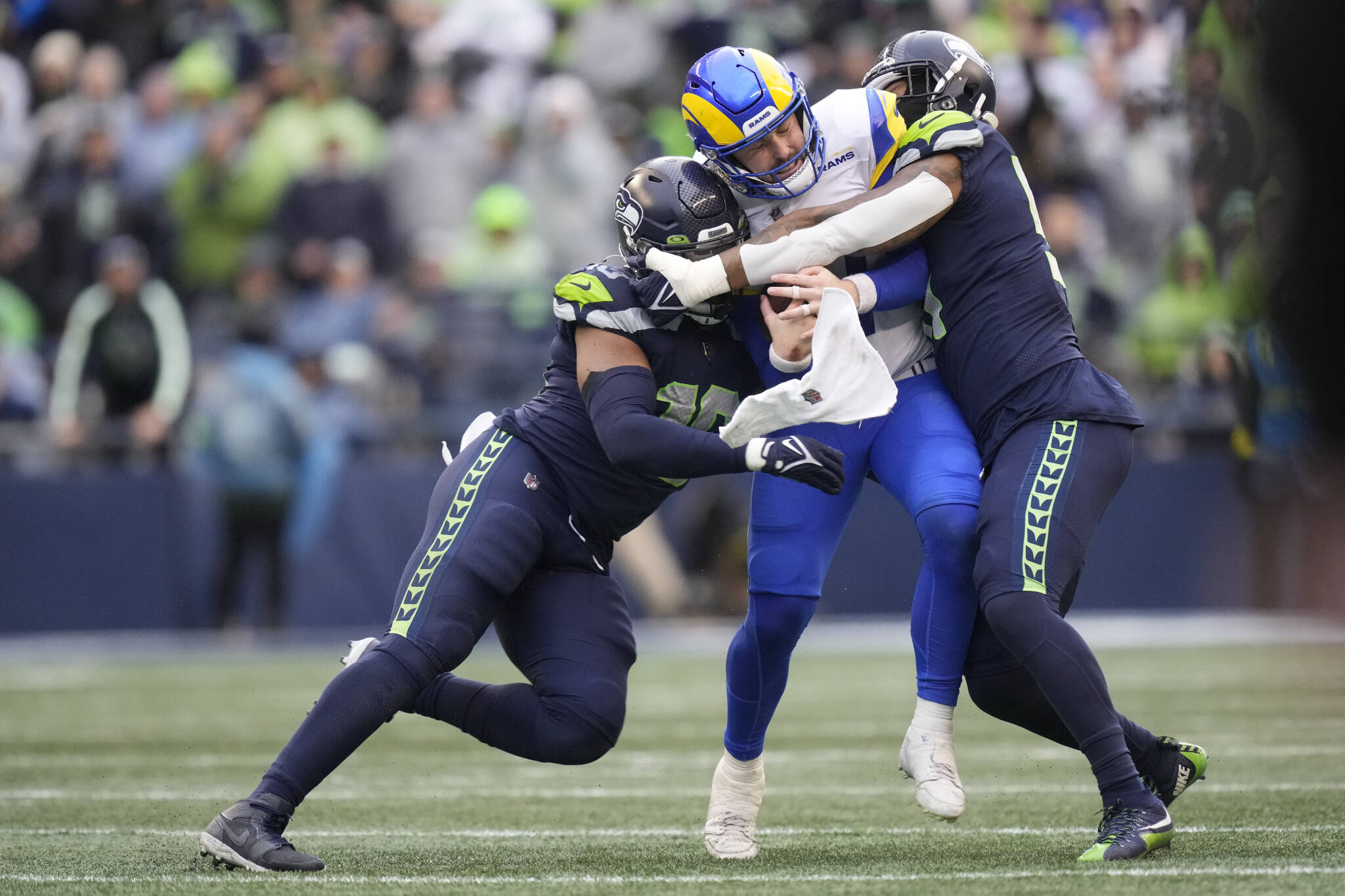 Seattle Seahawks linebackers Uchenna Nwosu (left) and Bruce Irvin sack Los Angeles Rams quarterback Baker Mayfield during a game Jan. 8 in Seattle. (AP Photo/Ben VanHouten)