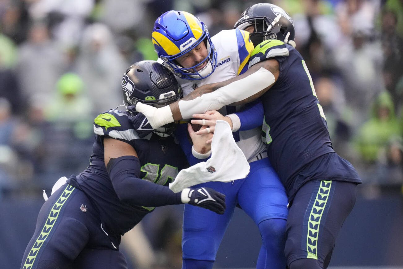 Seattle Seahawks linebackers Uchenna Nwosu (10) and Bruce Irvin (51) sack Los Angeles Rams quarterback Baker Mayfield (17) during an NFL football game, Sunday, Jan. 8, 2023, in Seattle, WA. The Seahawks defeated the Rams in overtime 19-16. (AP Photo/Ben VanHouten)