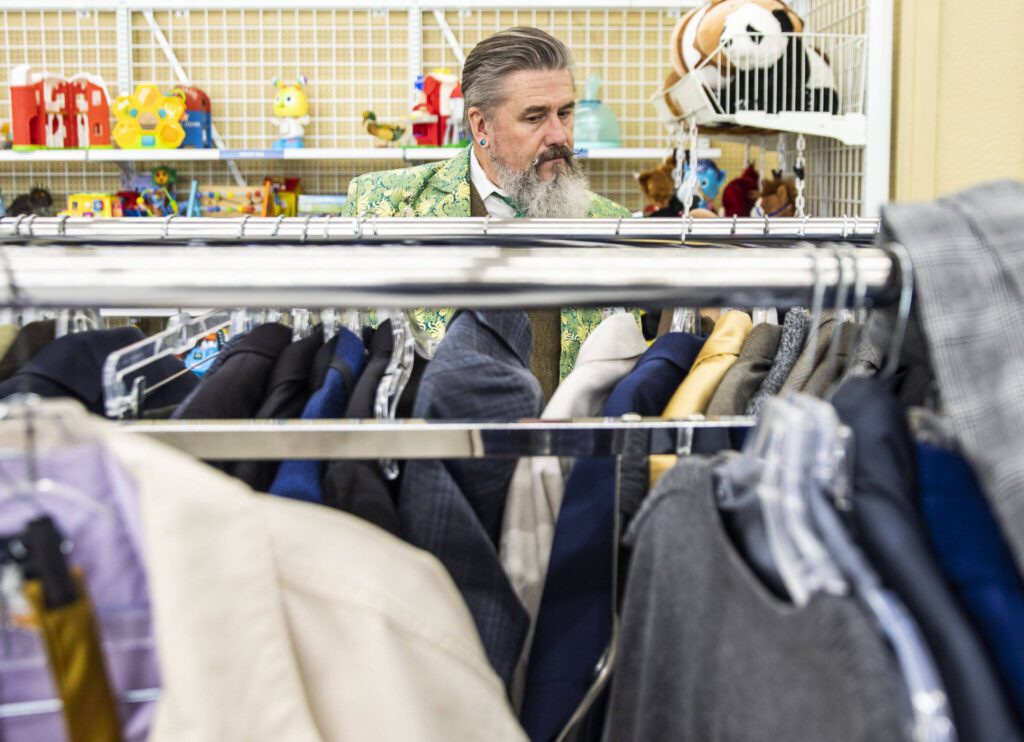 Tim Lambright browses the men’s suit jackets while putting together a spring themed outfit at Value Village. (Olivia Vanni / The Herald)
