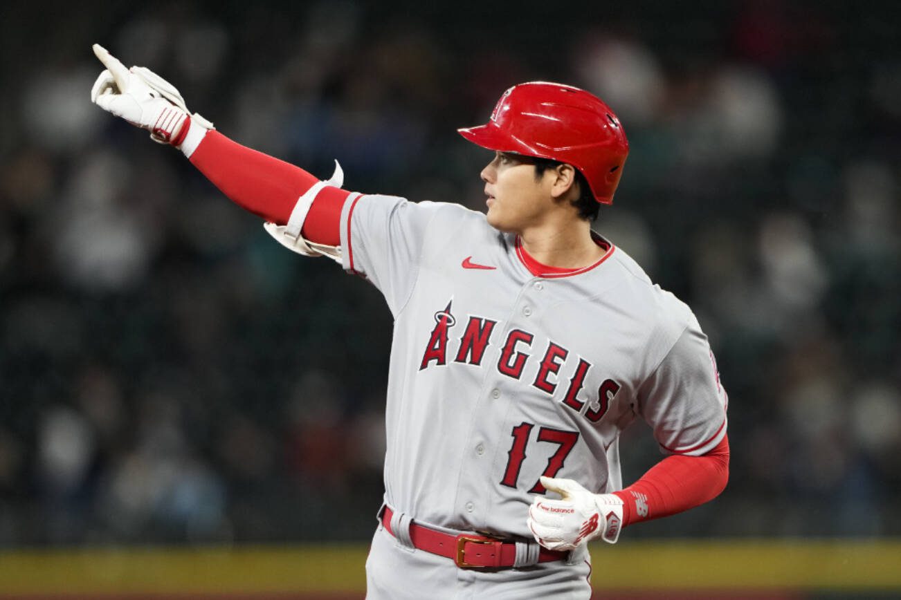 Los Angeles Angels designated hitter Shohei Ohtani points to the outfield as he runs the bases after hitting a two-run home run against the Seattle Mariners in the fifth inning during a baseball game Monday, April 3, 2023, in Seattle. (AP Photo/Lindsey Wasson)
