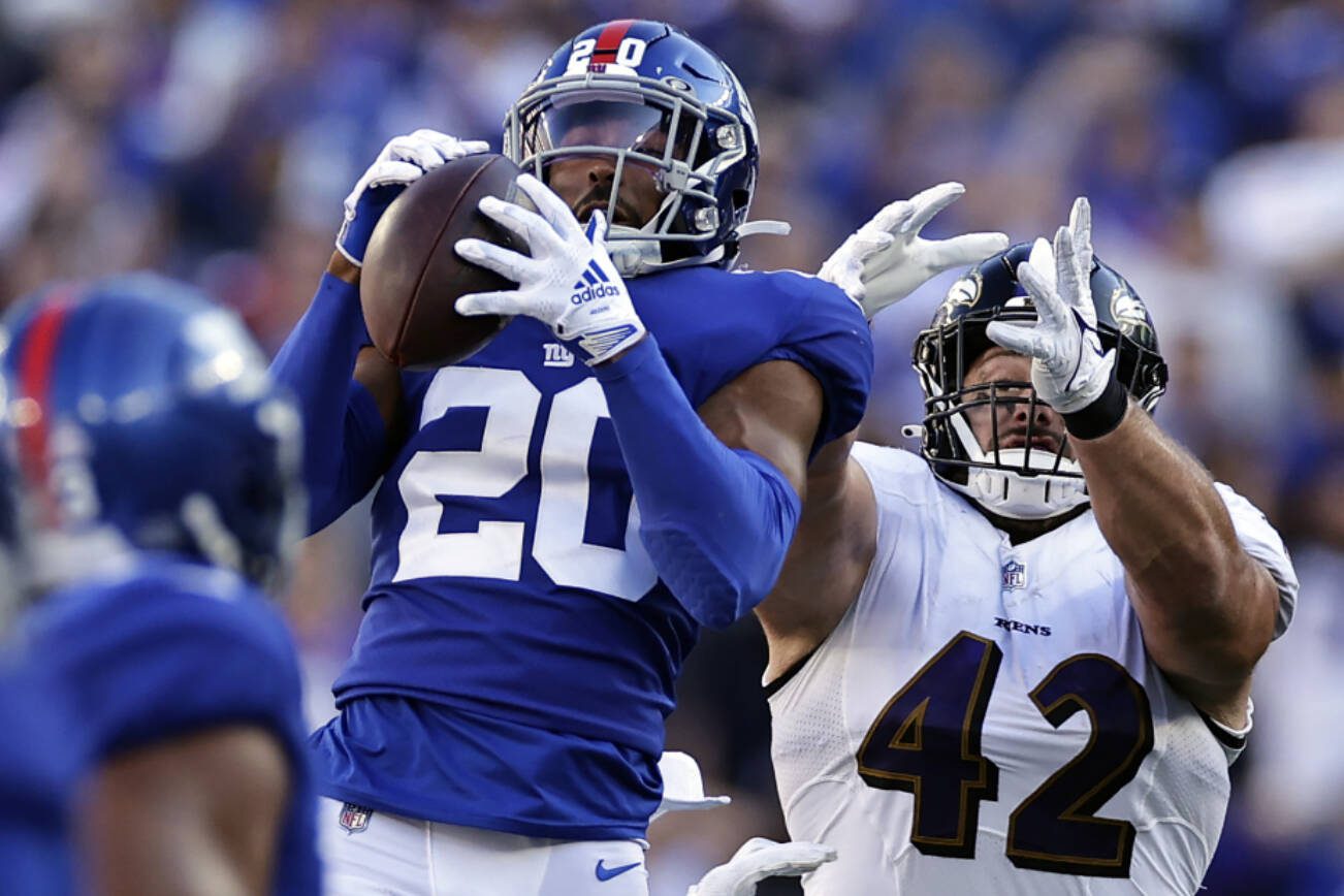 New York Giants safety Julian Love (20) intercepts the ball intended for Baltimore Ravens fullback Patrick Ricard (42) during an NFL football game Sunday, Oct. 16, 2022, in East Rutherford, N.J. (AP Photo/Adam Hunger)