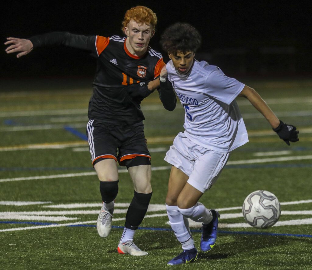 Monroe’s Nolan Kelly (10) and Shorewood’s Matthew Bereket (15) fight for the ball during a game between Monroe and Shorewood at Monroe High School on Friday, April 7, 2023 in Monroe, Washington. Shorewood won in double overtime, 3-2. (Annie Barker / The Herald)
